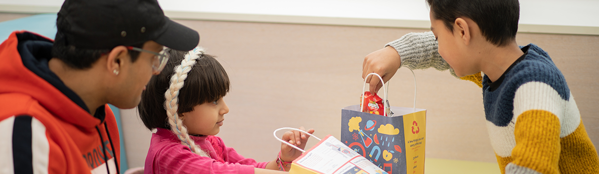 two children eating from lunch boxes in the cafe