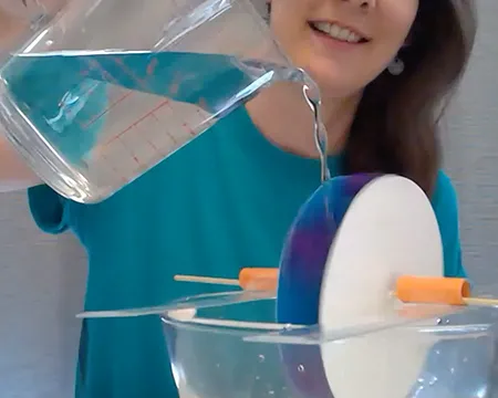 Pouring water on a homemade water wheel