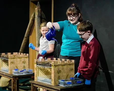 A science communicator and school pupils do a fun experiment in a science show about castles