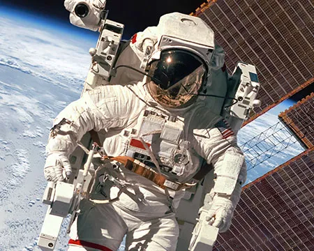 An astronaut on a space walk with the ISS and Earth in background
