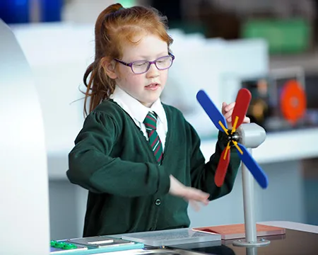 A pupil experiments with a model wind turbine