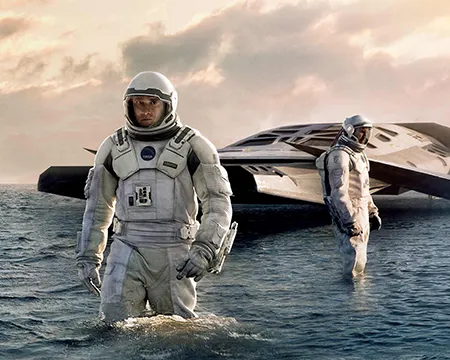 Interstellar. Astronauts emerge from a spacecraft onto the watery surface of a planet