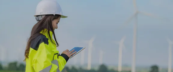 An engineer in a high vis vest at a wind farm.