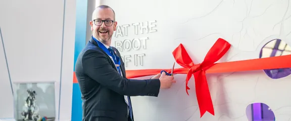 Professor William McLean cuts a red ribbon tied to launch the new endodontology exhibit at Glasgow Science Centre