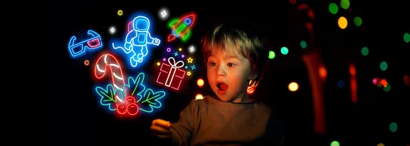 A young boy gazes in amazement at neon icons representing experiences at Glasgow Science Centre