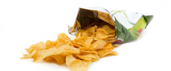 Crisps spill out from an open packet of crisps.