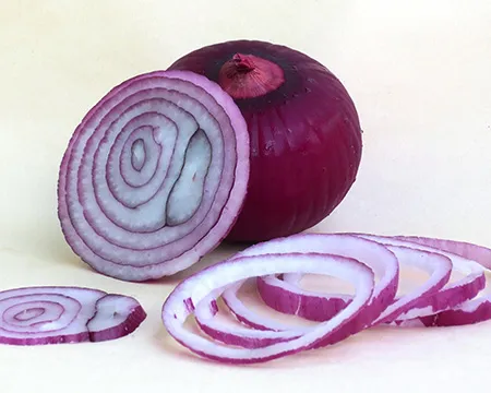 A red onion, partly sliced