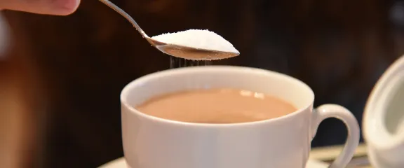 Adding a spoonful of sugar to a cup of tea