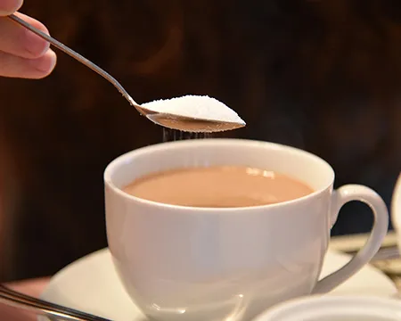 Adding a spoonful of sugar to a cup of tea