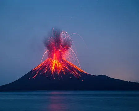 A volcano erupts against a dark sky