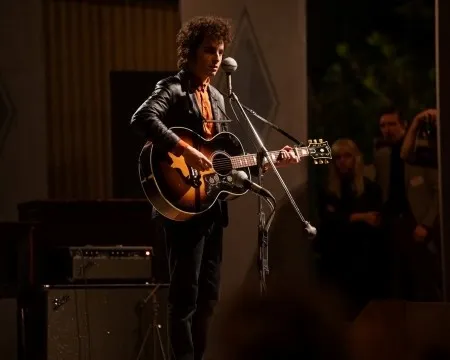 Timothée Chalamet playing guitar as Bob Dylan 